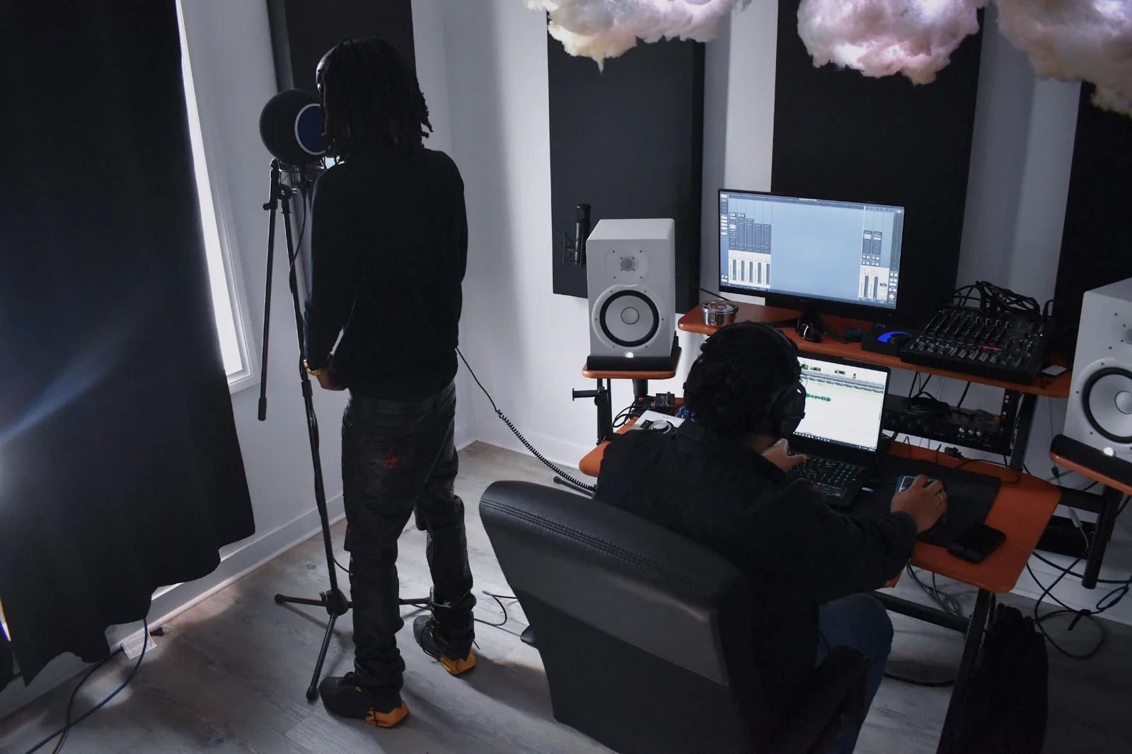 Vocal recording session with microphone and engineer at workstation
